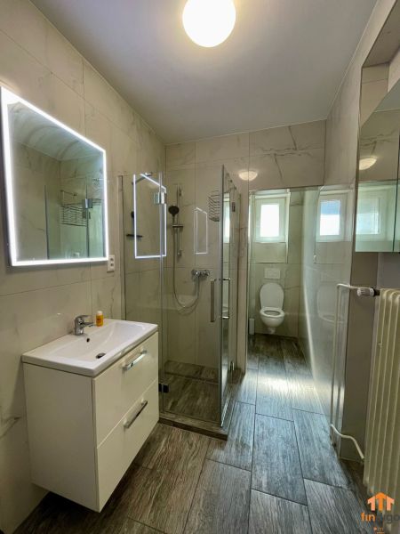 PRENÁJOM - 3-izbový byt priamo v centre Nitry s parkovaním a balkónom - Kúpeľňa v 3-izbovom byte s podlahou s dreveným dekorom a sprchovým kútom.
