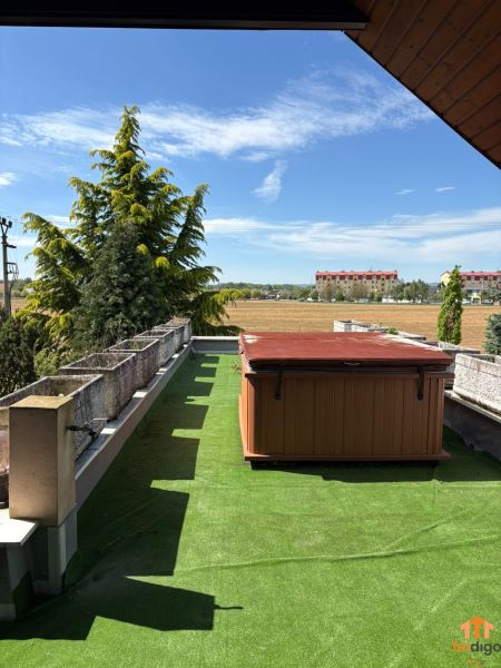 PREDAJ - 4-izbový luxusný rodinný dom s investičným pozemkom  - Terasa rodinného domu v Moravanoch nad Váhom s vírivkou a umelým trávnikom pod modrou oblohou.
