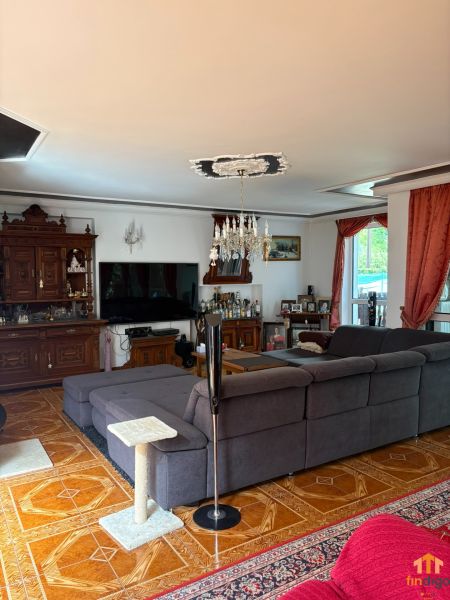 PREDAJ - 4-izbový luxusný rodinný dom s investičným pozemkom  - Obývacia izba v rodinnom dome s pohodlnou sedačkou a podlahou s dreveným dekorom.