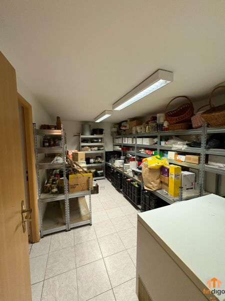 PREDAJ - 4-izbový luxusný rodinný dom s investičným pozemkom  - Sklad v rodinnom dome s regálmi plnými potravín a nádob.