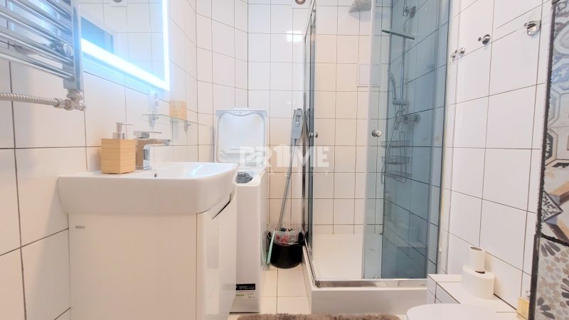 MODERNÝ 3i BYT, REKONŠTRUKCIA, Trnavská cesta, Ružinov  - Kúpeľňa s preskleným sprchovacím kútom, umývadlom a práčkou v 3-izbovom byte.