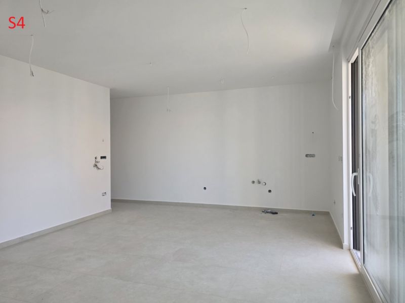 CHORVÁTSKO - Moderné apartmány 80 m od mora - SRIMA, VODICE - Priestranná miestnosť v 3-izbovom byte s bielymi stenami a veľkým oknom.