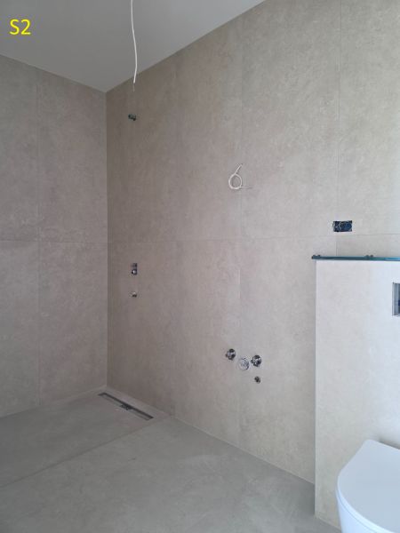 CHORVÁTSKO - Moderné apartmány 80 m od mora - SRIMA, VODICE - Kúpeľňa 3-izbového bytu s hladkými béžovými stenami a prípravou na sanitu.