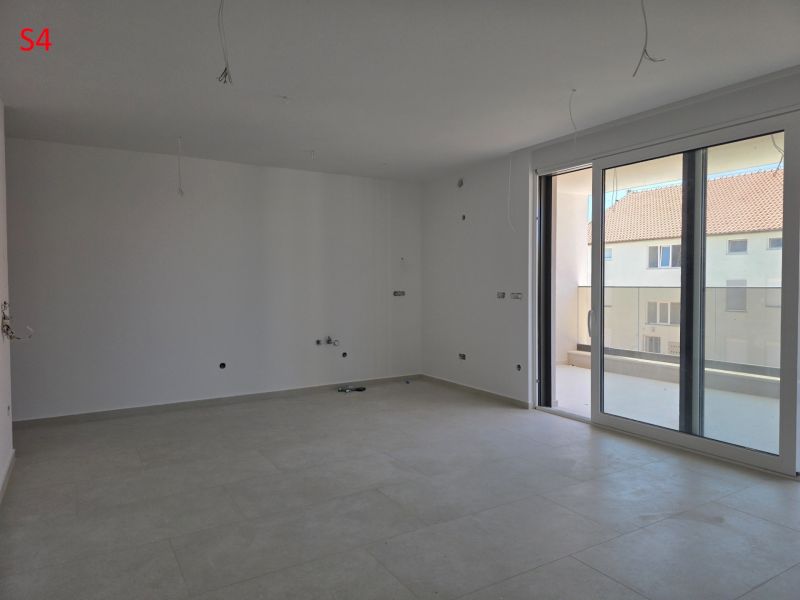CHORVÁTSKO - Moderné apartmány 80 m od mora - SRIMA, VODICE - Priestranná obývacia izba v 3-izbovom byte so svetlou podlahou a veľkými oknami.