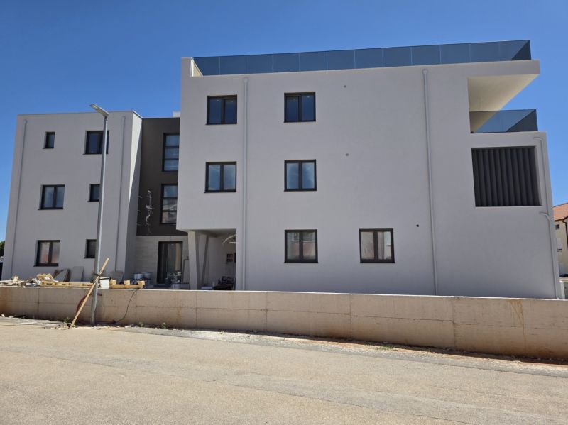 CHORVÁTSKO - Moderné apartmány 80 m od mora - SRIMA, VODICE - Novostavba 3-izbových bytov v meste Srima s čistou bielou fasádou.