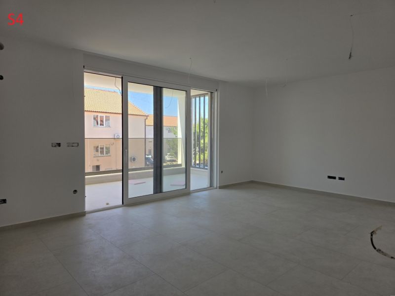 CHORVÁTSKO - Moderné apartmány 80 m od mora - SRIMA, VODICE - Interiér 3-izbového bytu s veľkými oknami a svetlou podlahou.