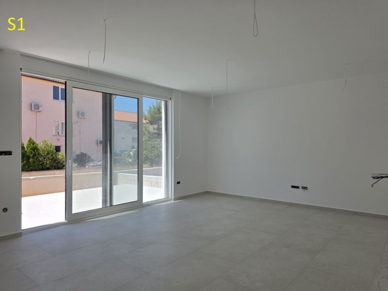 CHORVÁTSKO - Moderné apartmány 80 m od mora - SRIMA, VODICE - Priestranná miestnosť s veľkými oknami a podlahou s dreveným dekorom v 3-izbovom byte.
