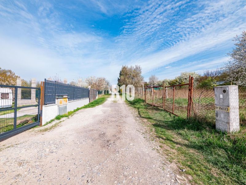 Záhrada/podnikanie?  2.000 m2 pozemok - 3 min. od mesta Nitra - Cesta medzi pozemkami na bývanie v Nitre, medzi oplotením a zelenou vegetáciou.