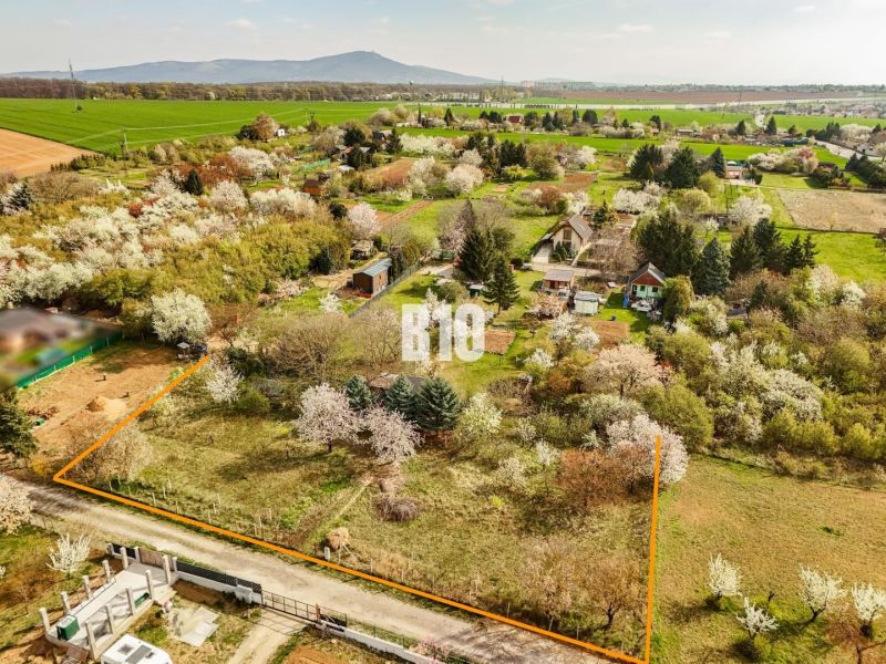 Záhrada/podnikanie?  2.000 m2 pozemok - 3 min. od mesta Nitra - Stavebný pozemok na bývanie v Nitre obklopený zeleňou a kvitnúcimi stromami.