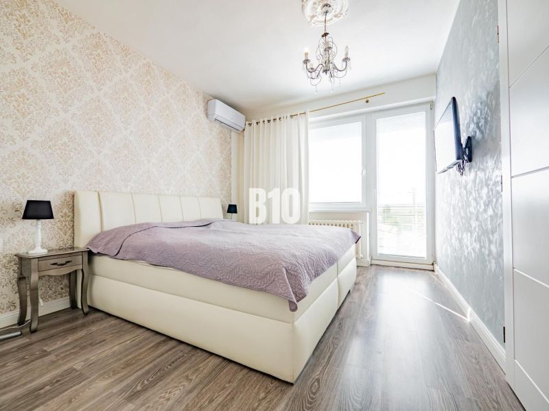 6 izb. RD bývanie / sídlo firmy, garáž, Nitra - Čermáň  /+ BONUS - Spálňa s posteľou, vzorovanou tapetou a podlahou s dreveným dekorom v rodinnom dome.