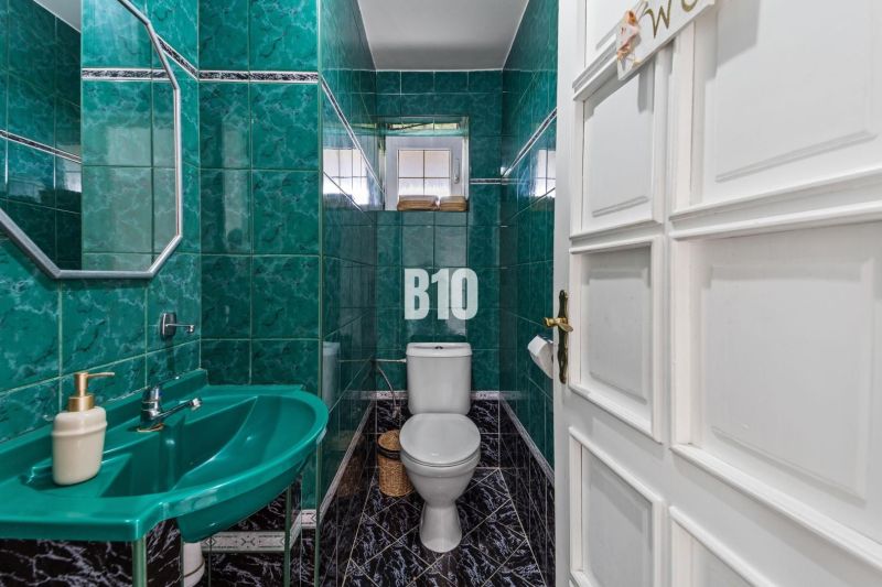 4i rodinný dom Lehota | 230 m² | Bazén | 85 m² garáž | 5 min. od Nitry - Kúpeľňa v rodinnom dome so zelenými obkladmi a umývadlom.