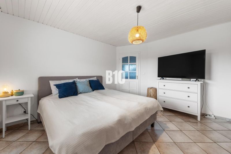 4i rodinný dom Lehota | 230 m² | Bazén | 85 m² garáž | 5 min. od Nitry - Spálňa v rodinnom dome s posteľou, televízorom a nočným stolíkom.