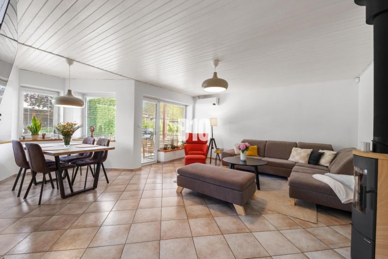 4i rodinný dom Lehota | 230 m² | Bazén | 85 m² garáž | 5 min. od Nitry - Priestranná obývacia izba v rodinnom dome s jedálenským stolom a pohodlnou pohovkou.