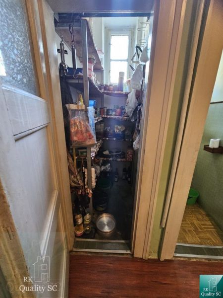 Bratislava I - NA PREDAJ INVESTIČNÝ KLENOT V STAROM MESTE: 2,5-izbový  - Špajza v 3-izbovom byte s policami a oknom, rôzne predmety na skladovanie.