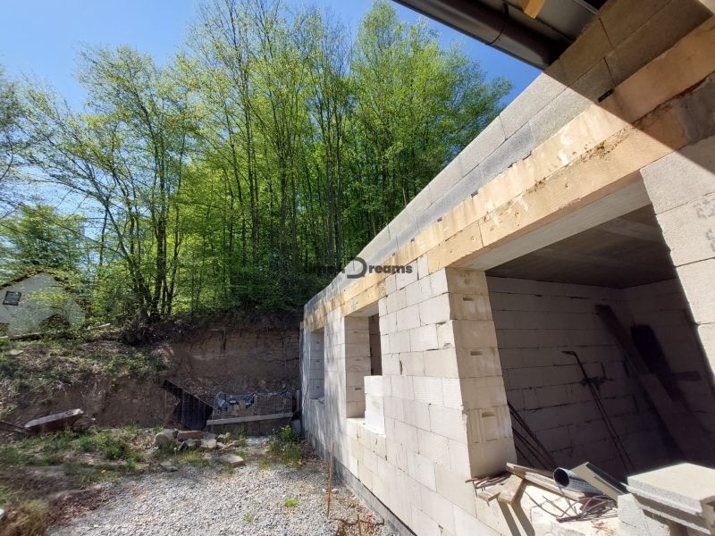 NA PREDAJ rozostavaný 5-izbový rodinný dom   - Stavba rodinného domu v Zvolene obklopená zeleňou a stromami.