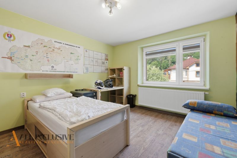 Na predaj 5-izb. dvojgen. rodinný dom, Dúbravica - Izba v rodinnom dome s mapou na stene, posteľou a podlahou s dreveným dekorom.