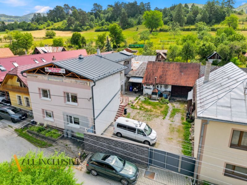 Na predaj 5-izb. dvojgen. rodinný dom, Dúbravica - Rodinný dom v Dúbravici obklopený zeleňou s parkovaním a susednými budovami.