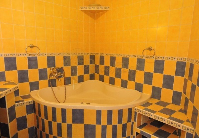 Nebytový priestor, Mikulášska, centrum mesta pod hradom - Na fotografii je žltá kúpeľňa s rohovou vaňou a farebnými obkladmi.