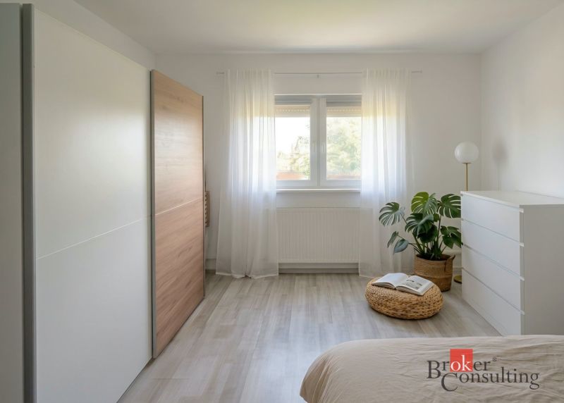 Priestranný 4i byt s parkovacím miestom 20min od Bratislavy - Svetlá spálňa v 4-izbovom byte s minimalistickým nábytkom a podlahou s dreveným dekorom.
