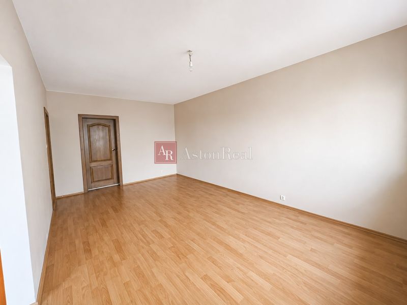 Predaj! slnečný 3-izbový byt s loggiou 74 m² Podbreziny - LM - Priestranná izba s podlahou s dreveným dekorom v 3-izbovom byte, dvere z tmavého dreva.