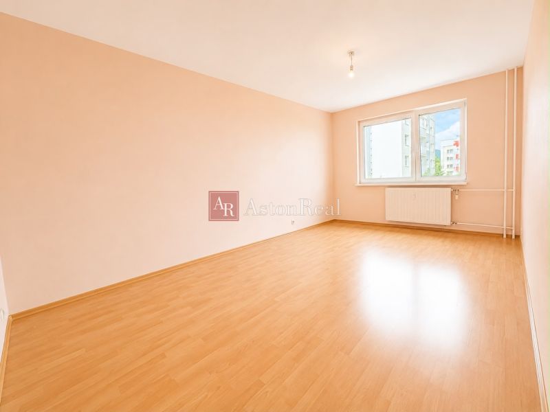 Predaj! slnečný 3-izbový byt s loggiou 74 m² Podbreziny - LM - Priestranná izba s podlahou s dreveným dekorom a veľkým oknom v 3-izbovom byte.