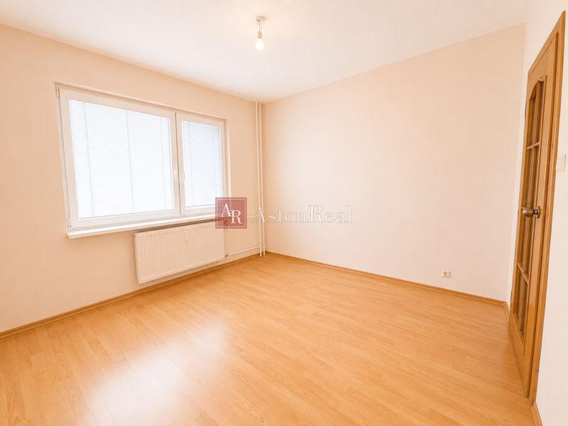 Predaj! slnečný 3-izbový byt s loggiou 74 m² Podbreziny - LM - Prázdna izba s podlahou s dreveným dekorom a bielymi stenami v 3-izbovom byte.