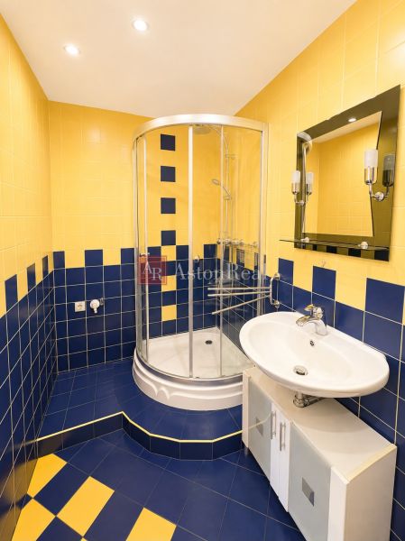 Predaj! slnečný 3-izbový byt s loggiou 74 m² Podbreziny - LM - Kúpeľňa v 3-izbovom byte s modro-žltými obkladačkami a sprchovacím kútom.