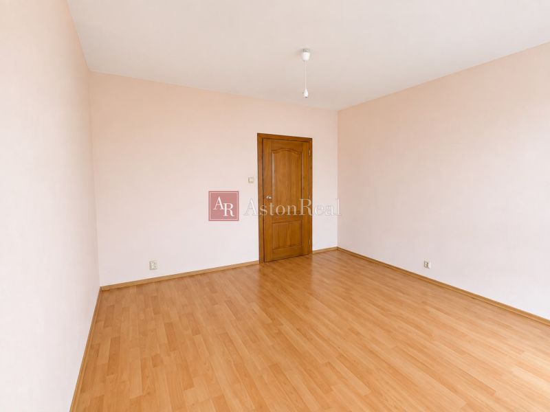 Predaj! slnečný 3-izbový byt s loggiou 74 m² Podbreziny - LM - Izba s podlahou s dreveným dekorom a svetlými stenami v 3-izbovom byte.