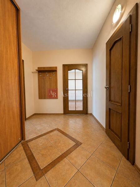 Predaj! slnečný 3-izbový byt s loggiou 74 m² Podbreziny - LM - Chodba v 3-izbovom byte s dlažbou a dreveným dekorom interiéru.