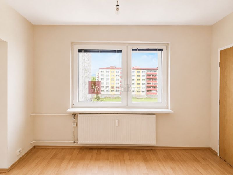 Predaj! slnečný 3-izbový byt s loggiou 74 m² Podbreziny - LM - Interiér 3-izbového bytu s podlahou s dreveným dekorom a veľkými oknami.
