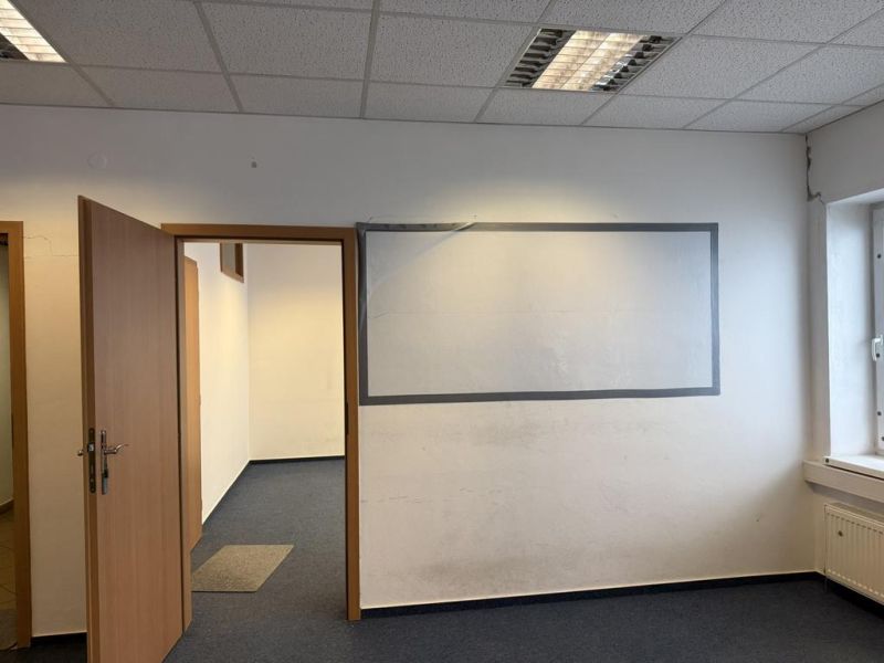 Kancelárske, obchodné a skladové priestory od 14m2 do 500m2 v areáli. - Kancelária s kobercom, oknom a otvorenými dverami vo Skladoch a halách.