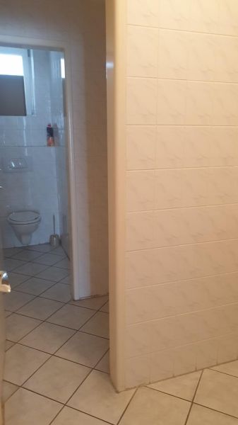 Kancelárske, obchodné a skladové priestory od 14m2 do 500m2 v areáli. - Toaleta so vstupnými dverami, obklopená dlažbou a obkladačkami, na ulici Nádražná.