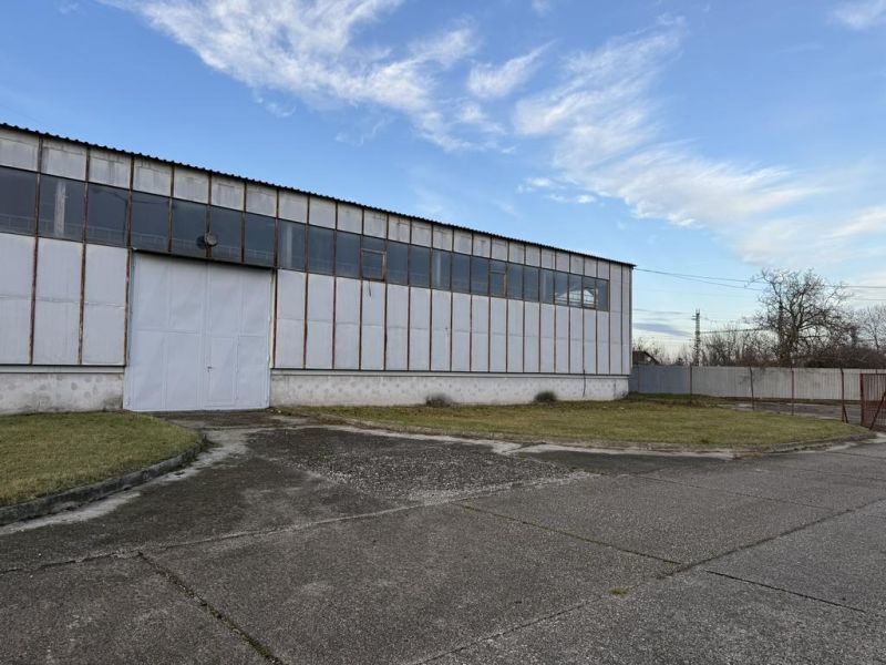 Sklad. priestory 200m2 - 1000m2, spevnené plochy do 6000m2 v areáli. - Sklady a haly v Bratislave - Rači s veľkými bielymi dverami a trávnatým okolím.