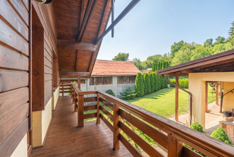 | Výnimočný rodinný dom s pozemkom 1516 m2 Nízke Tatry - Rodinný dom v Hornej Lehote s dreveným balkónom a záhradou so stromami.