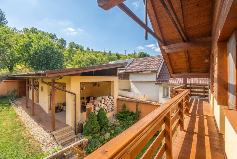 | Výnimočný rodinný dom s pozemkom 1516 m2 Nízke Tatry - Balkón rodinného domu v Hornej Lehote, drevené zábradlie, záhrada a kôlňa.