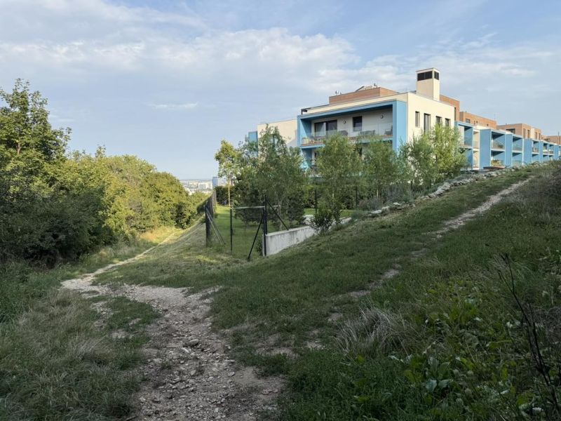 Nová cena ! Stavebný pozemok pre investíciu alebo rekreáciu.  - Chodník vedúci k moderným budovám obklopeným zeleňou na Frankovskej v Bratislave - Vinohrady. Pozemky - bývanie.