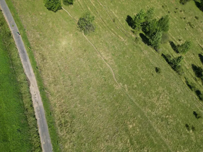 Vyšné Ružbachy – 1.016 m2 POZEMOK na CHATKU – Predaj - Letecká snímka krajiny pri Starej Ľubovni, zvýrazňujúca zelené lúky a stromovú scenériu.