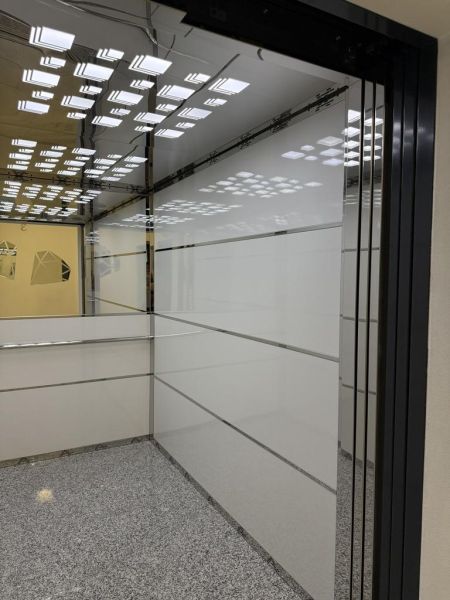Nové skolaudované byty a apartmány vo Vajnoroch. - Vstupný priestor s kovovými a sklenenými prvkami, osvetlenie odrážajúce sa na strope.