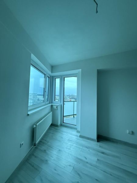 Nové skolaudované byty a apartmány v projekte Diamant. - Interiér 2-izbového bytu s podlahou s dreveným dekorom a výhľadom cez okno na mesto.