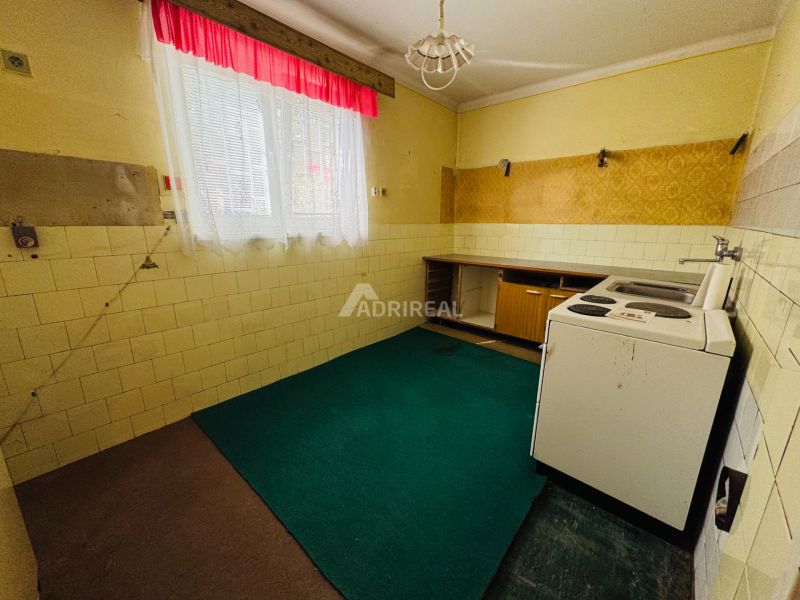 PREDAJ: 2i byt; 65 m2; CENTRUM - KRUPINA; 84.500 €  - Kuchyňa v 2-izbovom byte s lino podlahou a oknom so závesmi.