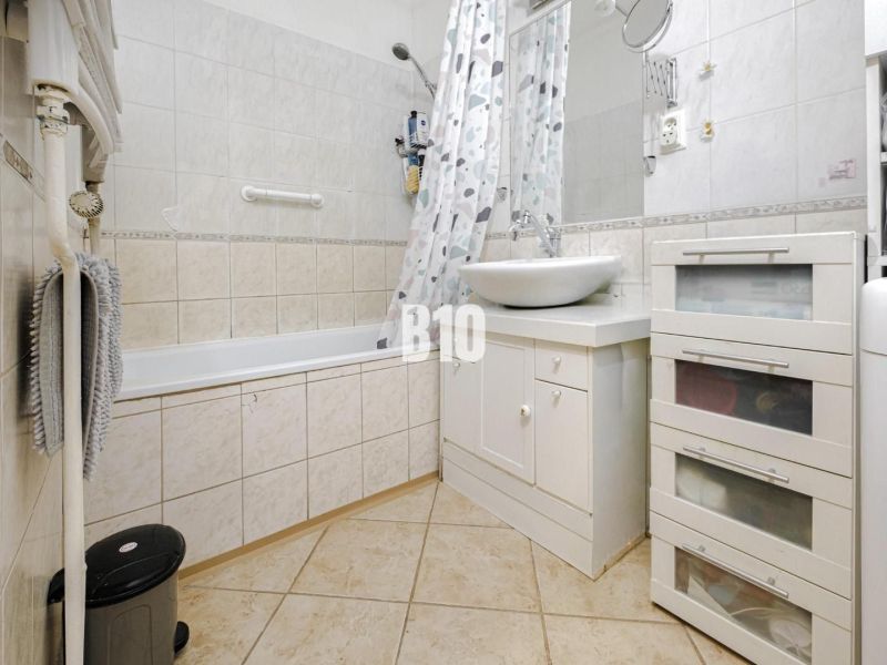 2-izbový byt s balkónom a klimatizáciou | Štúrova, Nitra - Kúpeľňa v 2-izbovom byte s vaňou a bielym umývadlom na skrinke.