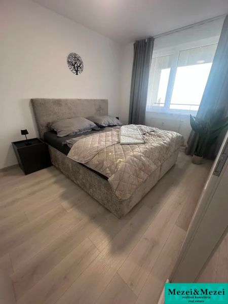 Prenájom 2 izbového bytu ARBORIA Trnava - Spálňa v 2-izbovom byte s posteľou a podlahou s dreveným dekorom.