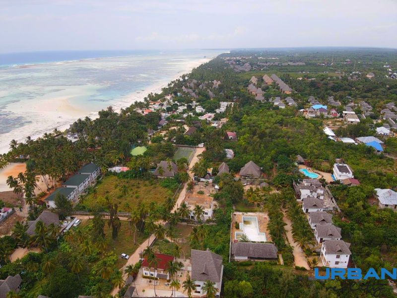 SAMOSTATNE STOJACA VILA MAPUMZIKO S 2 IZBAMI NA ZANZIBARE  - Pohľad na pobrežie a rodinné domy vo Fumba Town, obklopené tropickou prírodou.