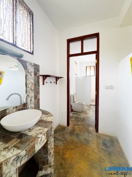 SAMOSTATNE STOJACA VILA MAPUMZIKO S 2 IZBAMI NA ZANZIBARE  - Kúpeľňa v rodinnom dome so zaujímavou mozaikovou umývadlovou doskou a oddeleným WC.