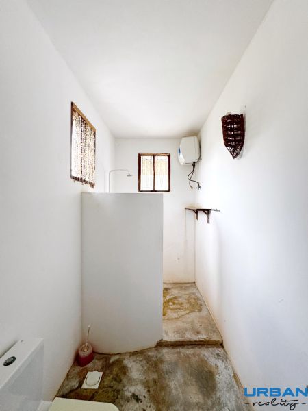 SAMOSTATNE STOJACA VILA MAPUMZIKO S 2 IZBAMI NA ZANZIBARE  - Kúpeľňa v rodinnom dome s bielymi stenami, sprchovým kútom a oknami.