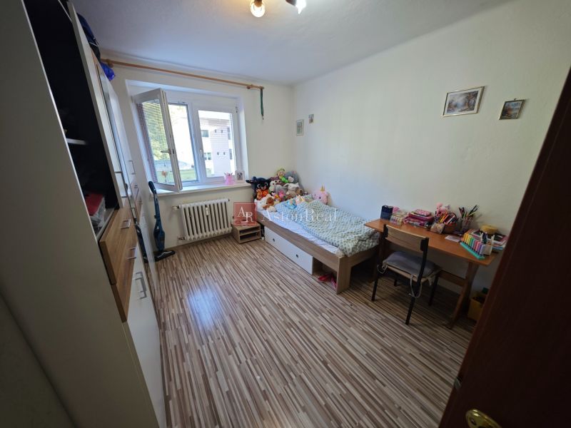 PREDAJ 2-izbový byt Harmanec 56 m2 s balkónom  - Detská izba s podlahou s dreveným dekorom v 2-izbovom byte plná hračiek.
