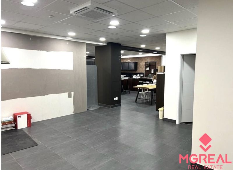 PRENÁJOM: Obchodné priestory 238m2, parkovanie, Ružinov - Obchodné priestory s keramickou podlahou, stropnými svetlami a sedením v pozadí.