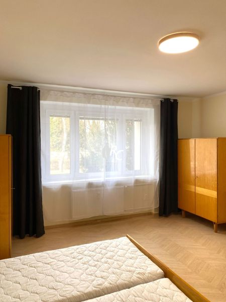 Prenájom 2-izbového bytu, Martin - centrum - Svetlá spálňa s veľkým oknom a podlahou s dreveným dekorom v 3-izbovom byte.