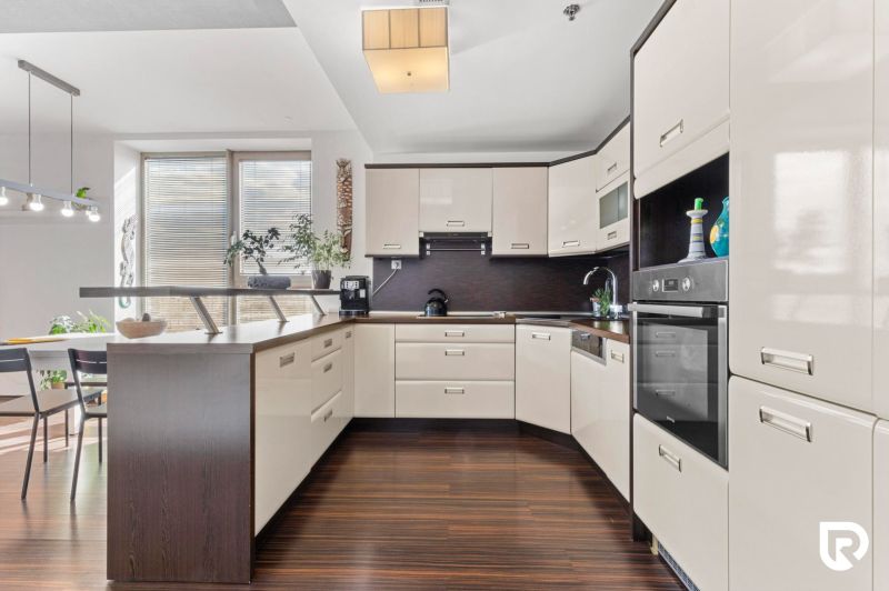 Apartmán vhodný na Airbnb aj rodinné bývanie | Vienna Gate - Kuchyňa v 3-izbovom byte s podlahou s dreveným dekorom a rohovou linkou.