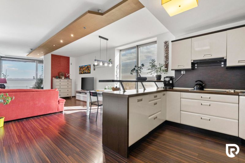Apartmán vhodný na Airbnb aj rodinné bývanie | Vienna Gate - Kuchyňa v 3-izbovom byte s podlahou s dreveným dekorom a svetlým nábytkom.